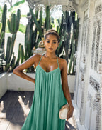 Woman in a aquamarine jumpsuit standing in front of cacti