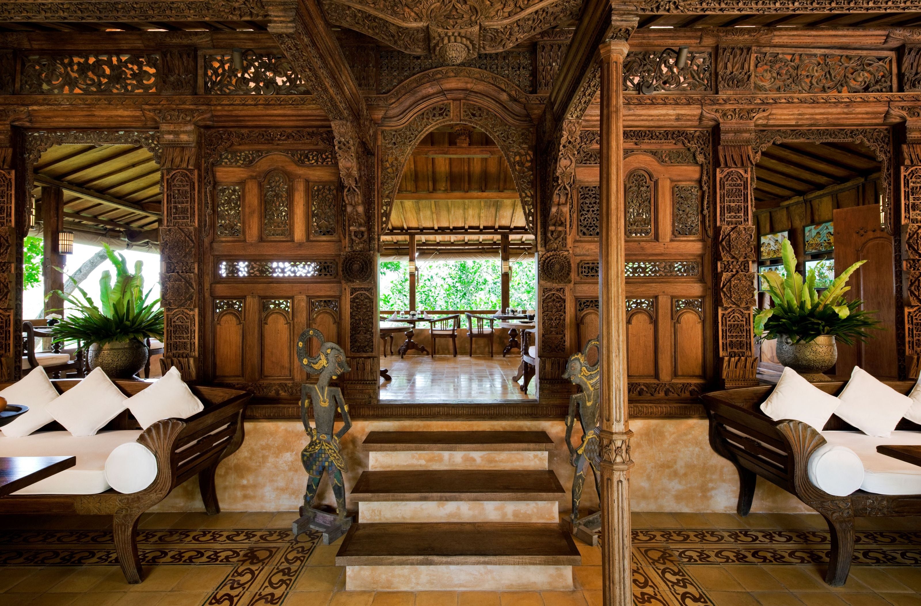 Ornately carved wooden interior with seating areas and decorative elements.