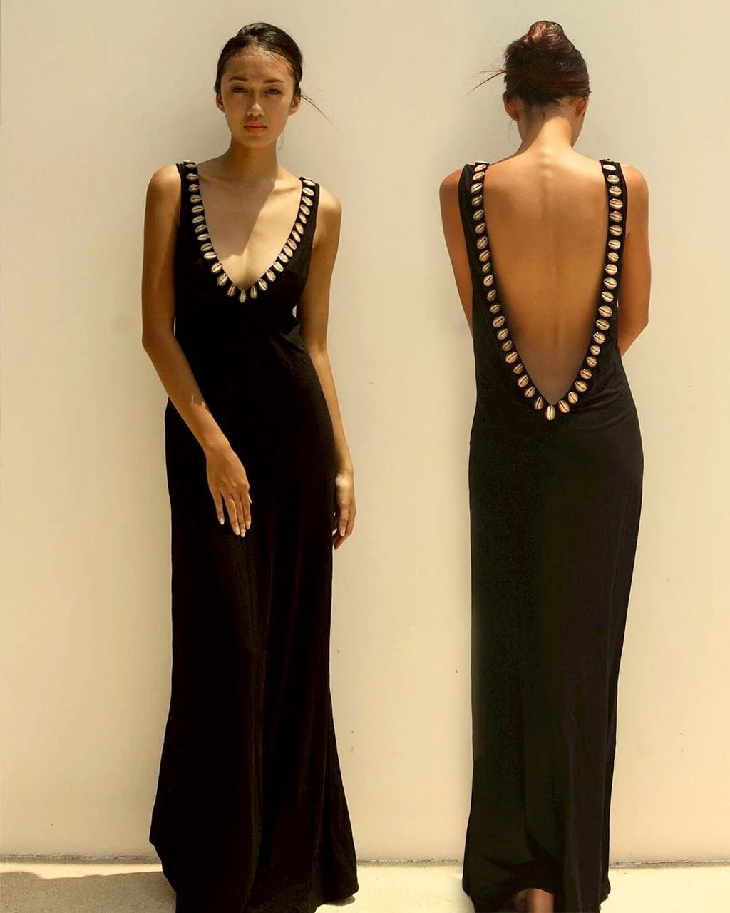 Black evening gown with open back design worn by a model against a plain background