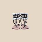 Pair of sandals with decorative shell straps on a white background