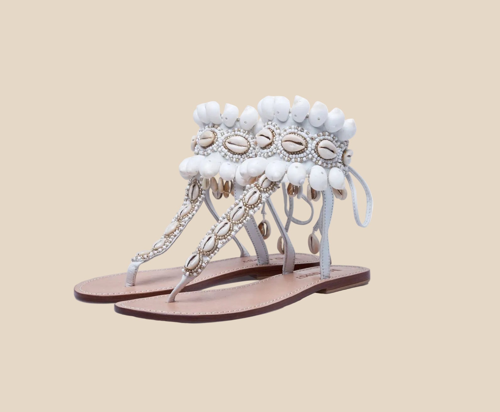 Decorative shell  sandals with beads and chains on a white background