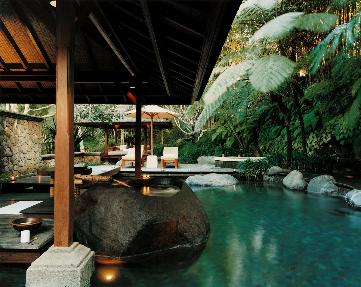 Outdoor setting with a pool, wooden structure, and lush greenery