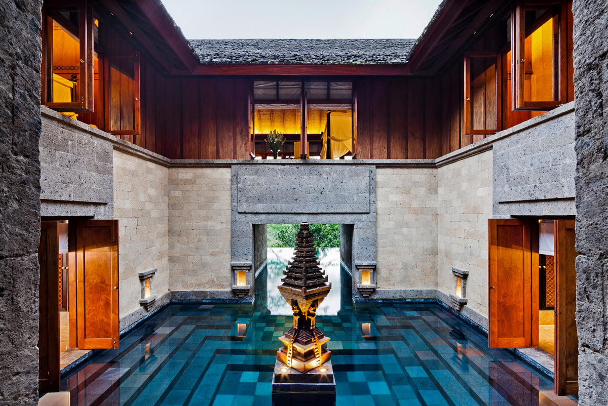 Interior courtyard with a central water feature and wooden doors in a modern architectural setting.