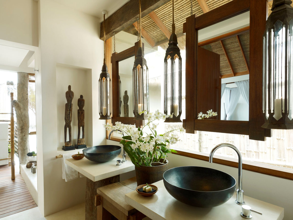 Tropical Modern bathroom with large mirrors, hanging lights, and a sink.